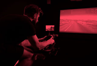 Man on spin bike watching virtual class.